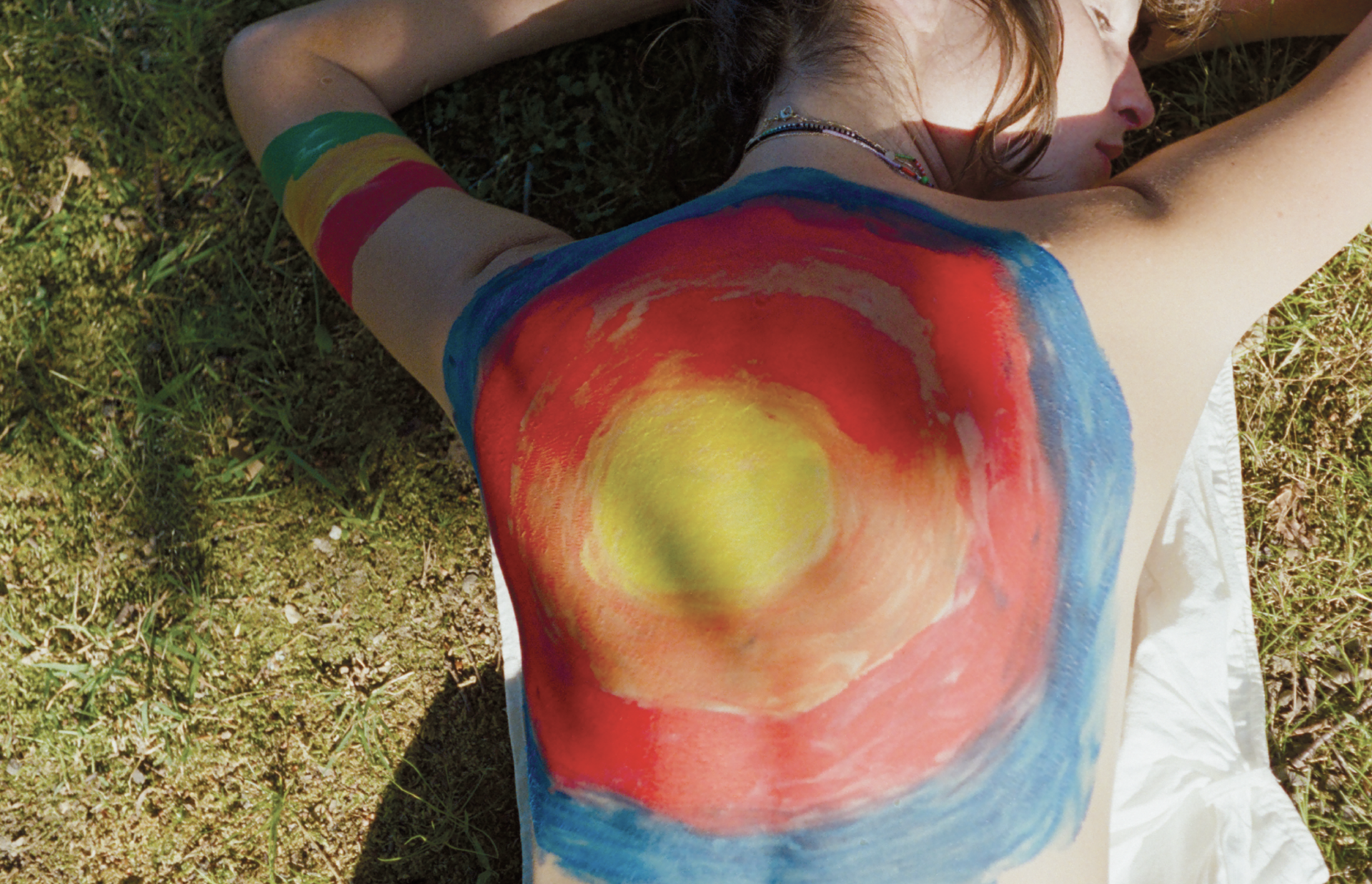 photo d'un dos peint comme un soleil de multiples couleurs
