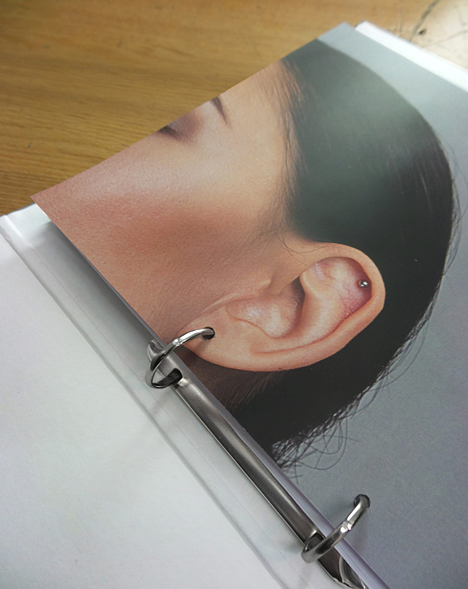 Classeur ouvert dont la boucle forme une boucle d'oreille à une photo de femme