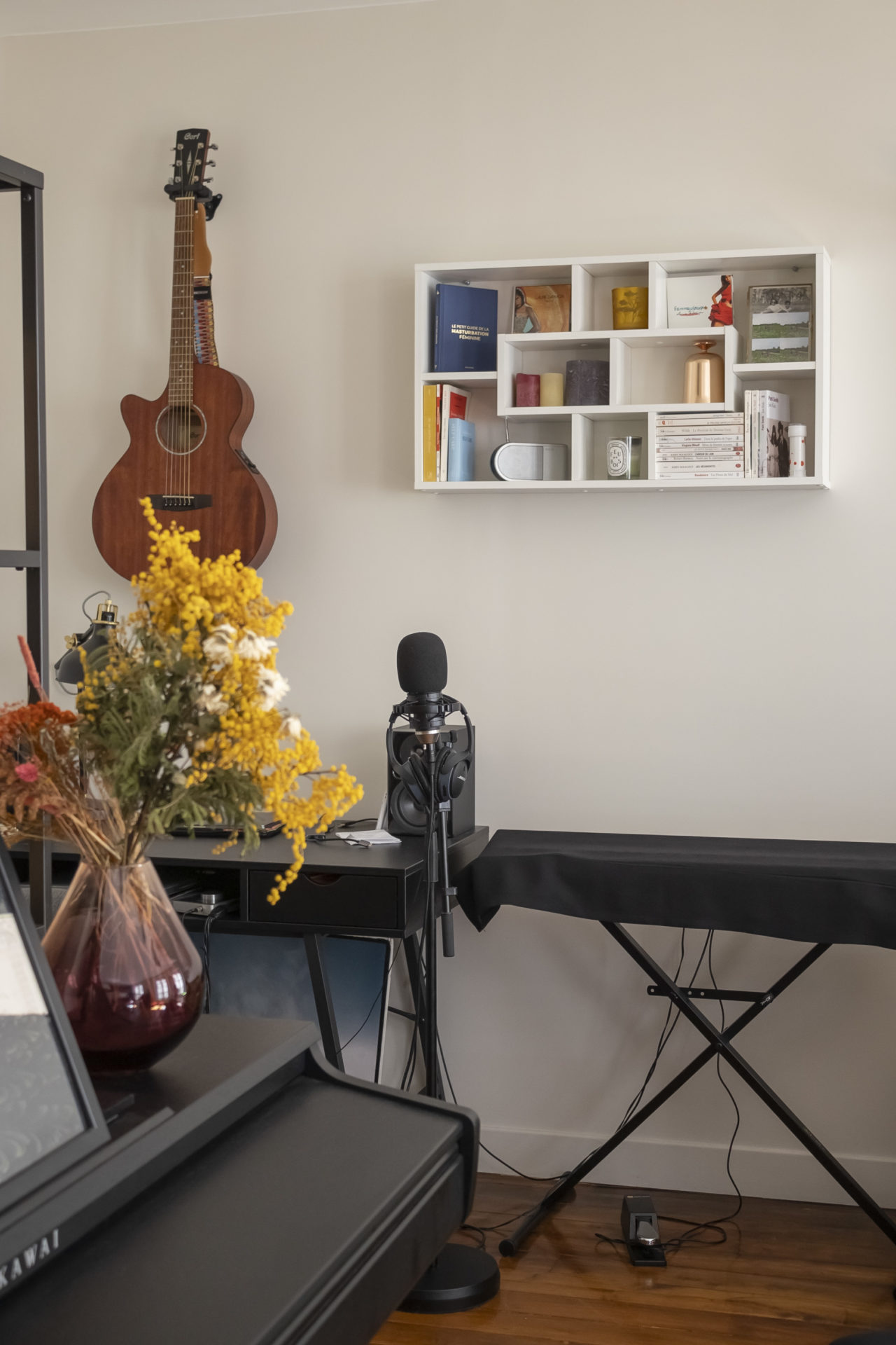 Intérieur de Laurie Darmon avec une guitare sur le mur, un piano et un micro posé