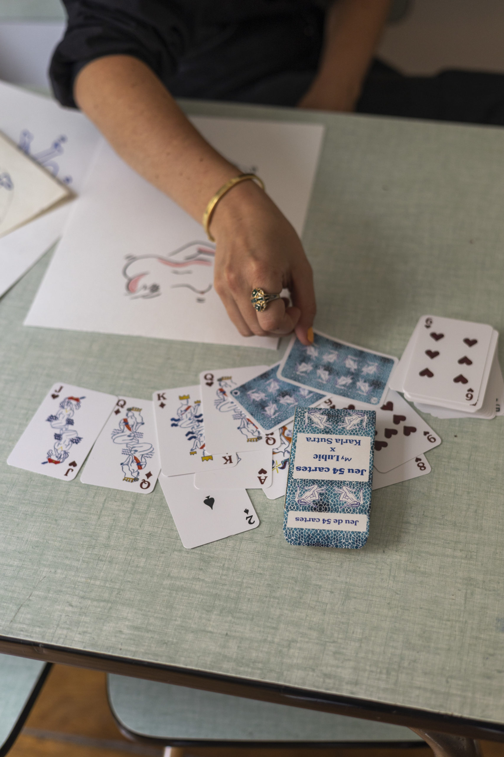 Karka Sutra montrant son jeu de cartes personnalisées 