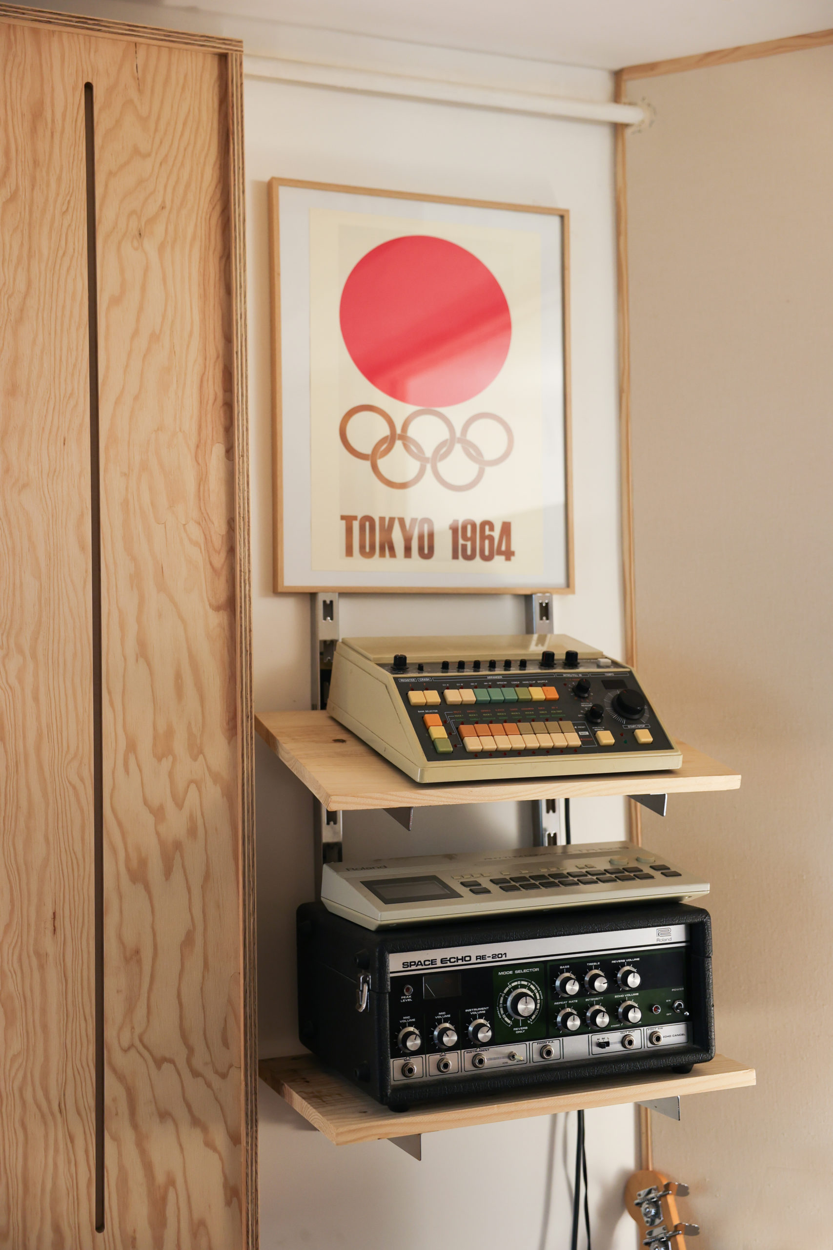 Cadre des JO de Tokyo posé sur des étageres avec du matériel de musique vintage