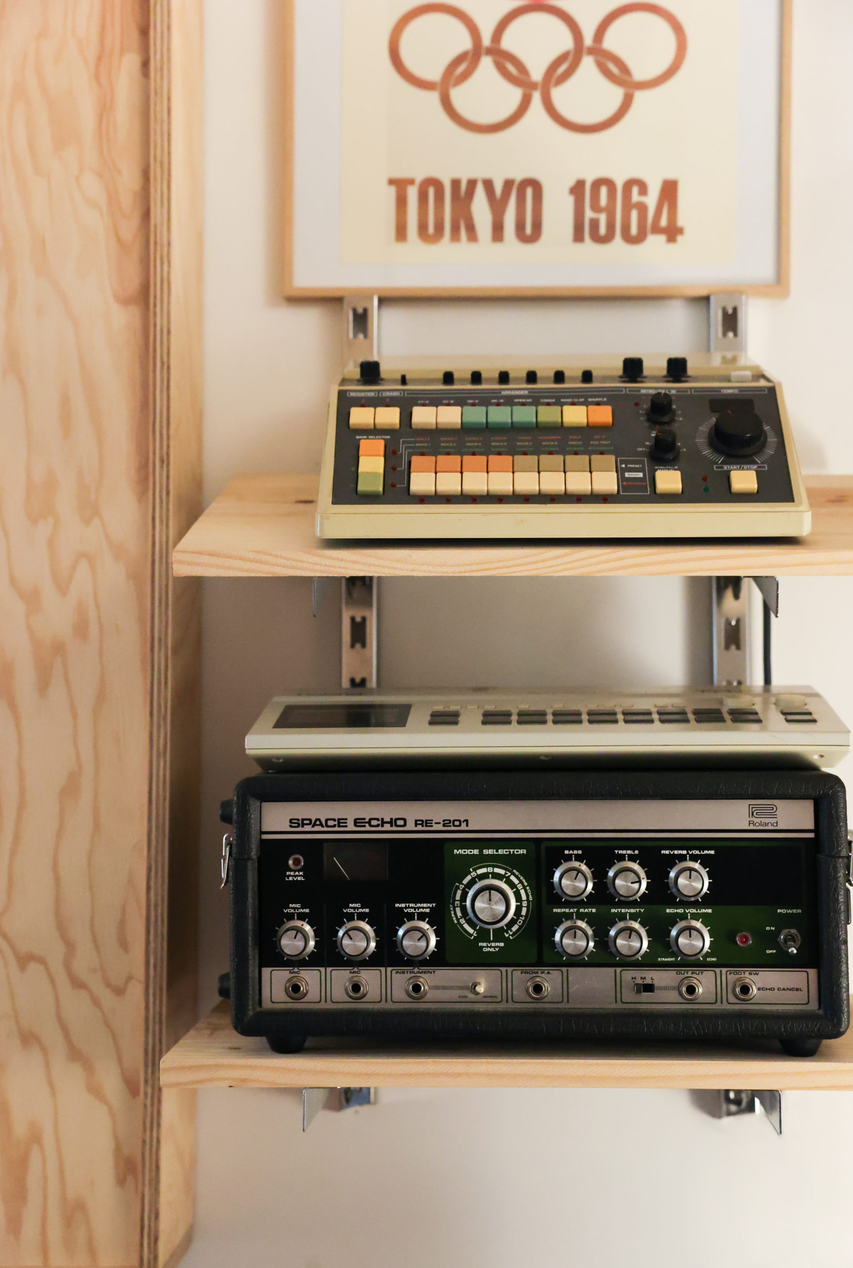 Cadre des JO de Tokyo posé sur des étageres avec du matériel de musique vintage
