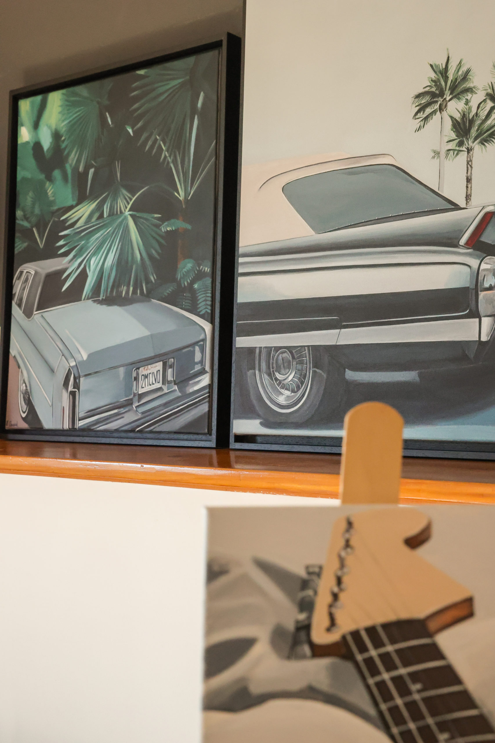 Trois peintures de Morgane Clavaud représentant des voitures anciennes américaines et un manche de guitare