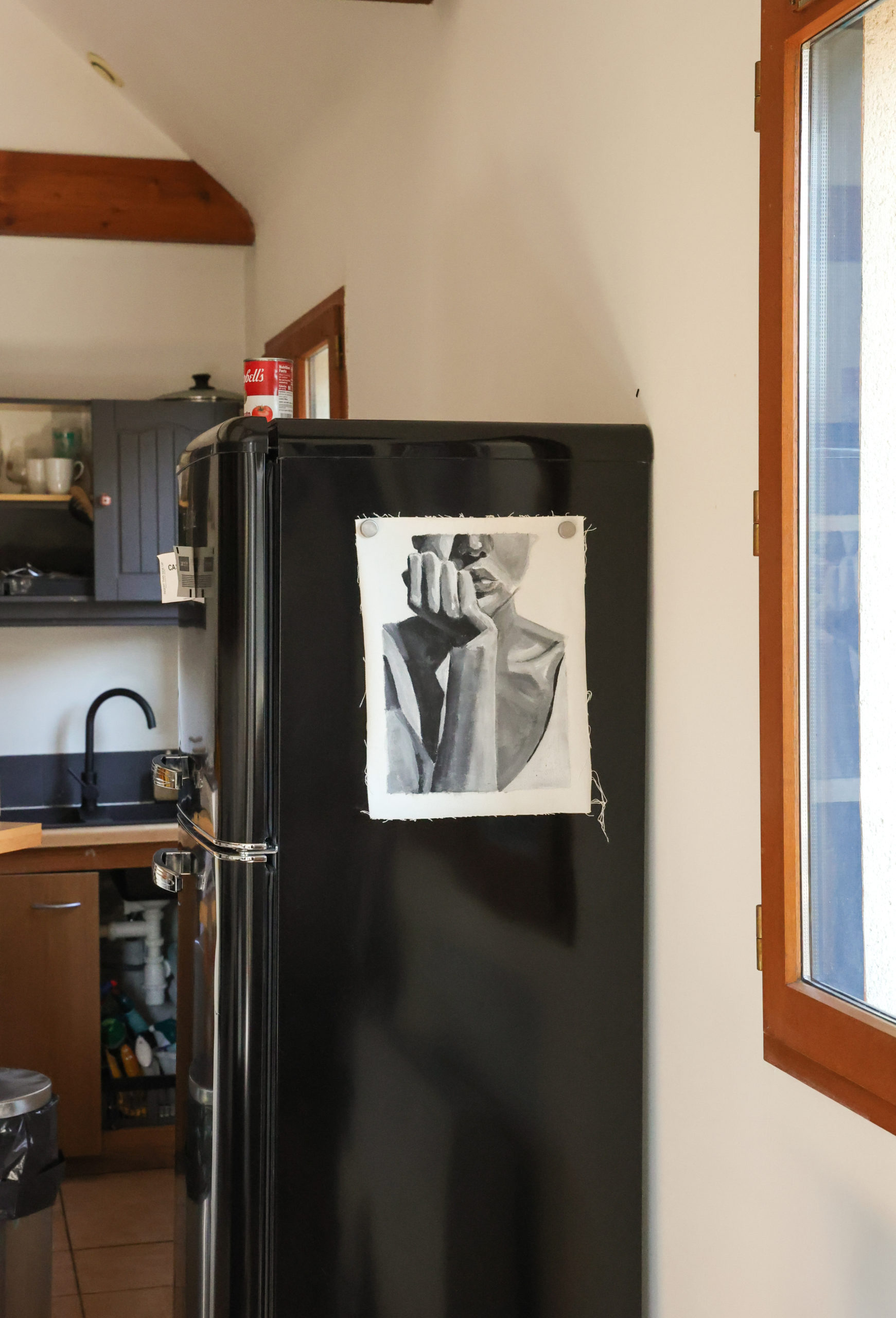 Peinture en noir et blanc d Morgane Clavaud accroché sur son frigo noir