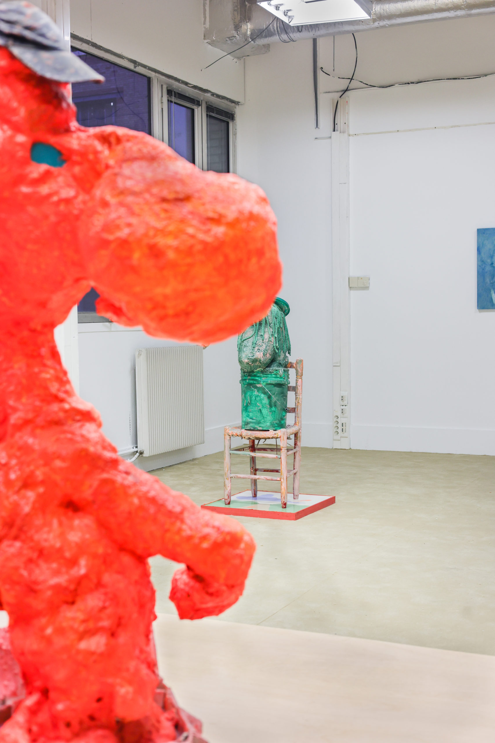salle. d'exposition composé d'une sculpture orange et d'une autre verte sur une chaise dans l'espace des Gia à Poush Manifesto