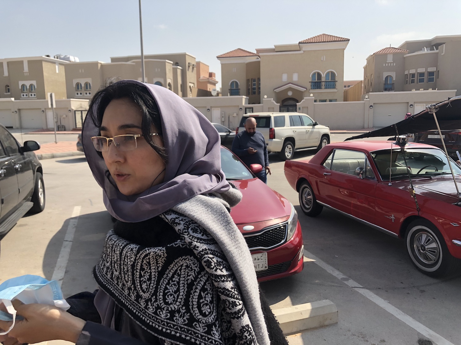 la realisatrice Maha Al Saati en tournage extérieur devant 2 voitures rouge