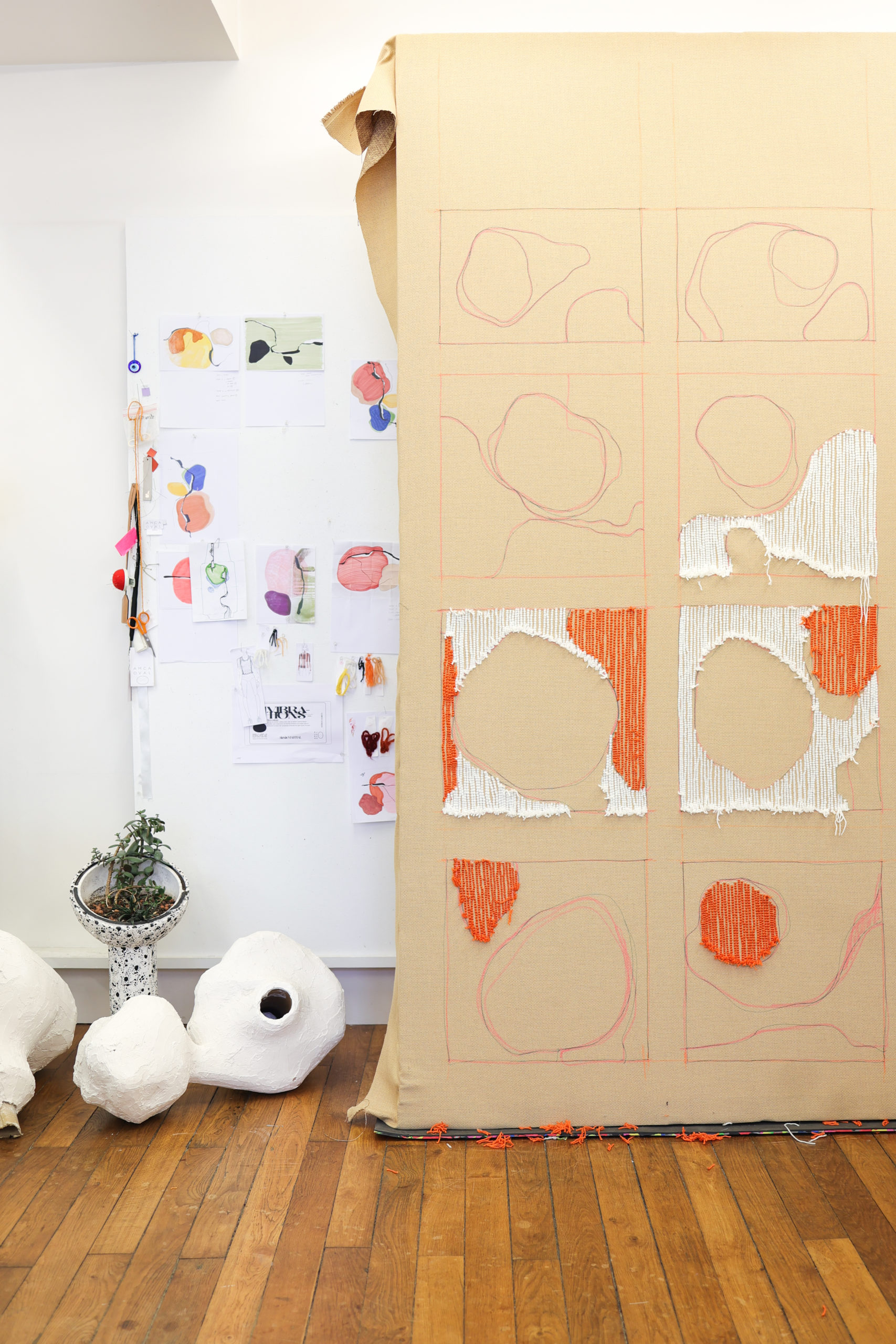 Mur avec test de création de tapis orange et blanc. Mur avec esquisse d'aquarelle multicolore accroché