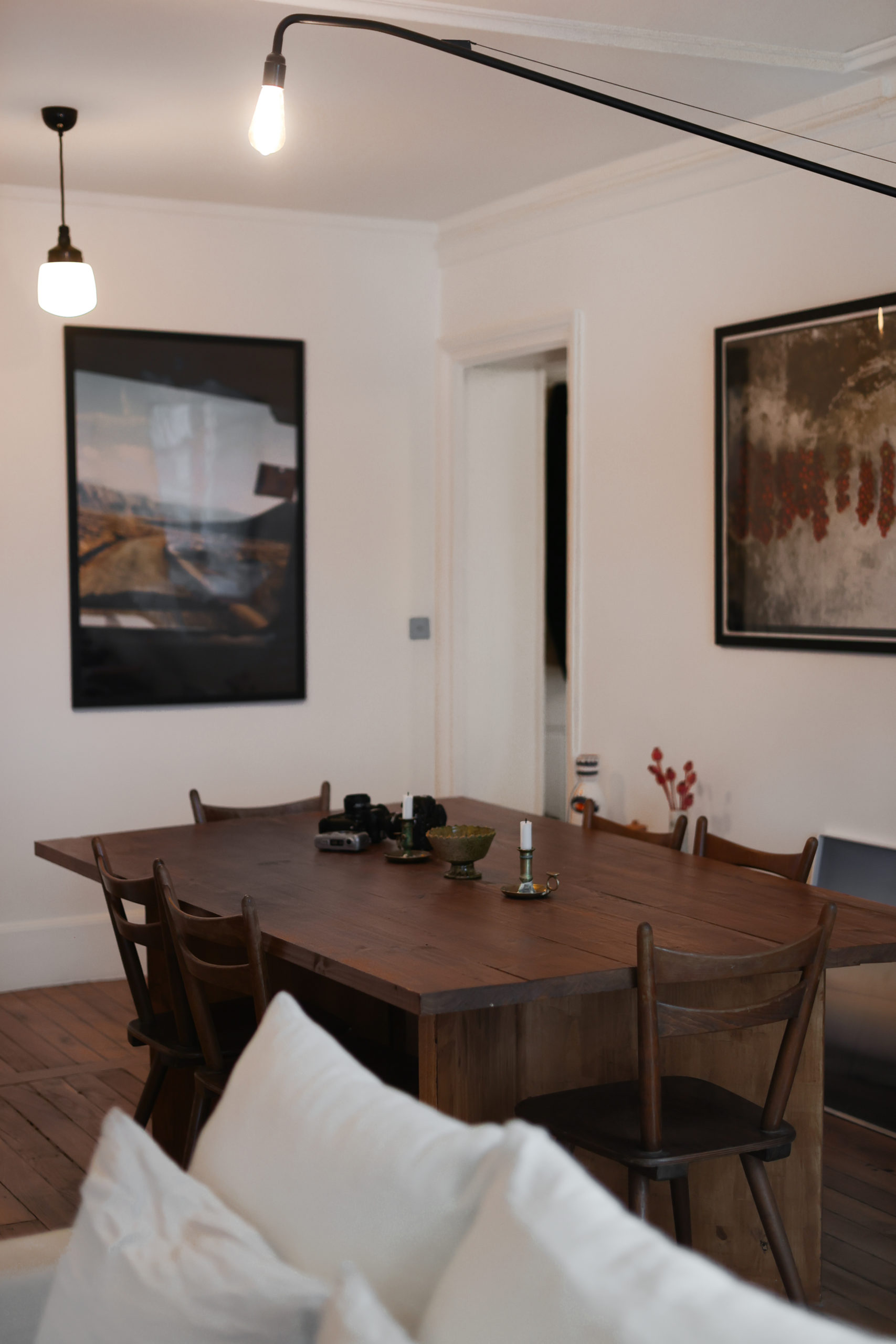 Interieur de Bastien Lattanzio avec une table à manger vintage et des photos accrochées aux murs