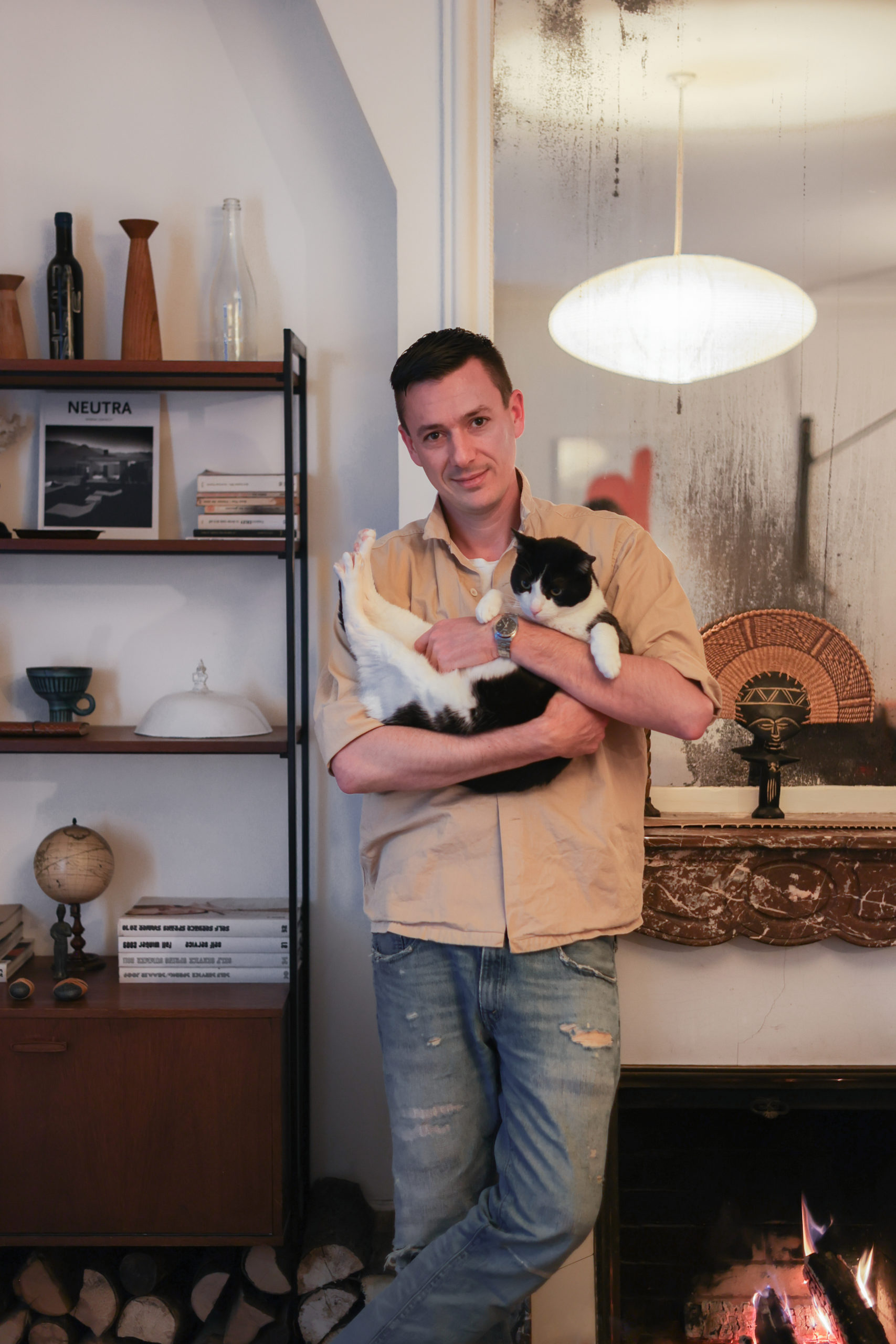 Le photographe Bastien Lattanzio avec son chat posant devant sa cheminée