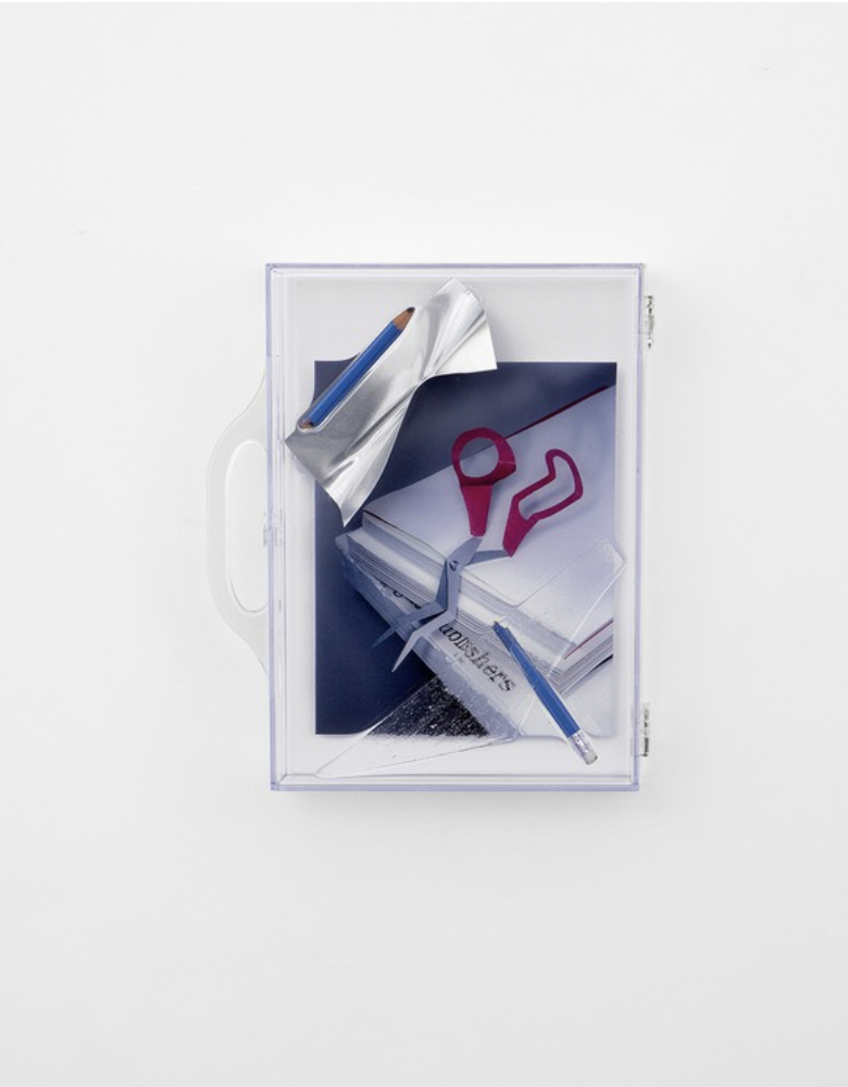 Oeuvre de Vytautas Kumza représentant une valise transparente contenant la photo d'une paire de ciseaux déformé 