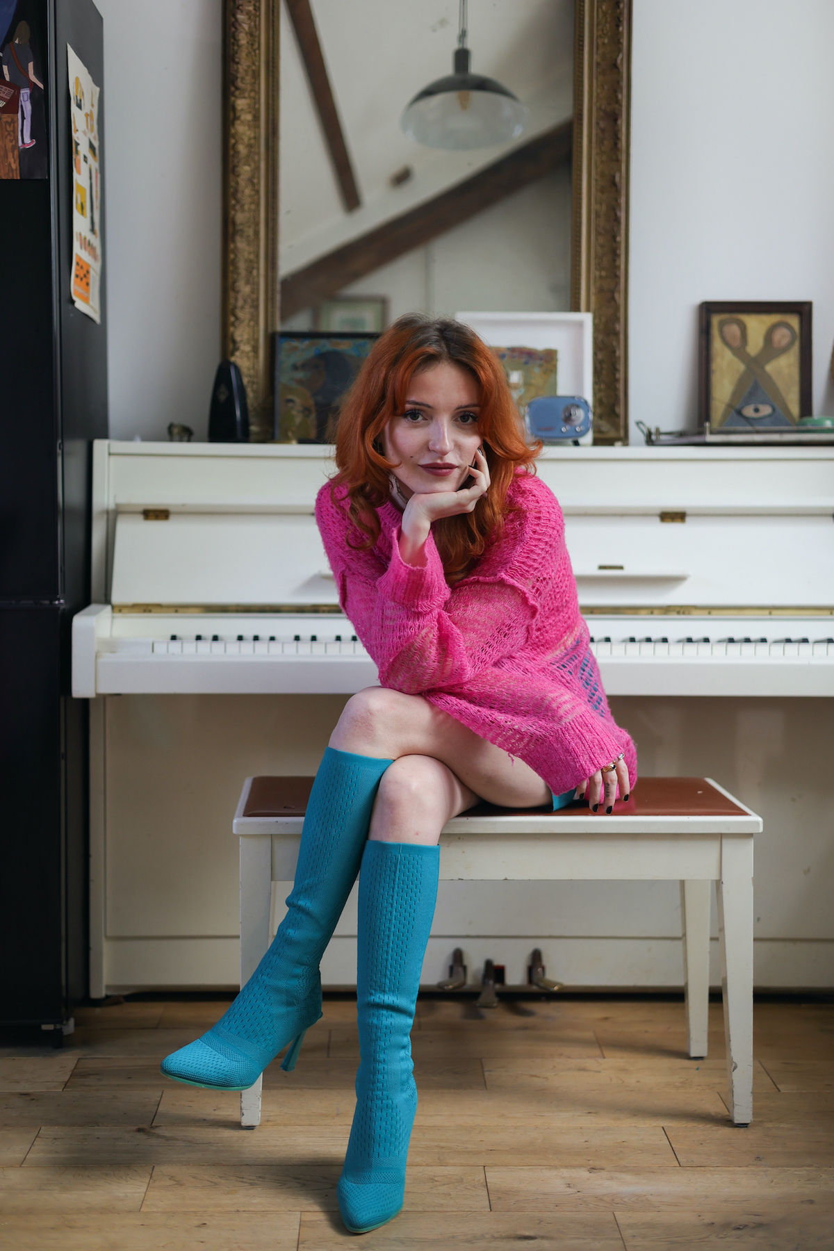 Portrait d'Emma Bergmann en rose et bleu assise devant son piano blanc